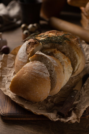 Sliced bread with knife on wood table. Homemade bread at wooden tabletop as baking conceptの写真素材