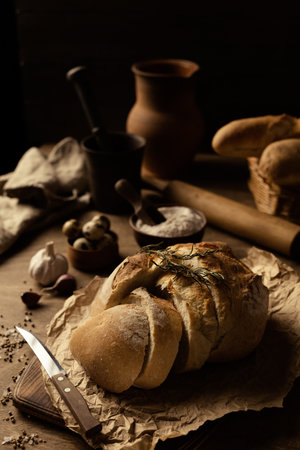Sliced bread with knife on wood table. Homemade bread at wooden tabletop as baking conceptの写真素材