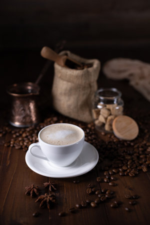 Cup of coffee and milk with beans on wooden table. Homemade coffee at table backgroundの写真素材