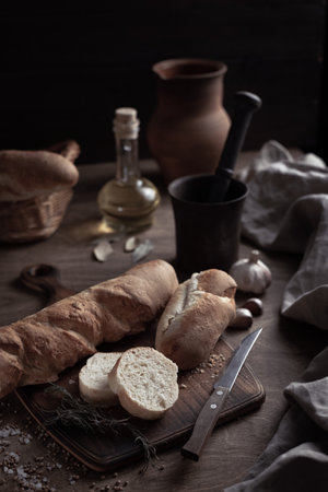 Sliced homemade bread at cutting board on wood table. Bread at wooden tabletop as baking conceptの写真素材