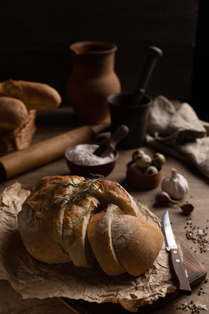 Homemade bread with parchment paper on wood table. Bread at wooden tabletop as baking conceptの写真素材