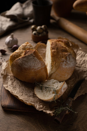 Homemade bread with parchment paper on wood table. Bread at wooden tabletop as baking conceptの写真素材