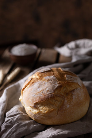 Fresh bread and table cloth at wooden table. Bakery still life and bread on wood tabletopの写真素材