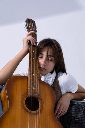 Young woman holdilng acoustic guitar. Musician sitting in studio with classic guitarの写真素材
