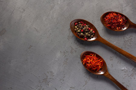 Variety of spices in spoon on concrete stone table background. Cooking food ingredients at kitchen table top viewの写真素材