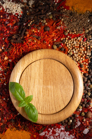 Wooden plate and variety of spices on table background. Food spice and ingredients at kitchen table closeupの写真素材