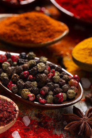 Pepper spice mix in spoon and variety spices on table background. Dried spice and seeds as ingredients at kitchen table closeupの写真素材