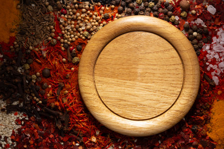 Wooden plate and variety of spices on table background. Food spice and ingredients at kitchen table closeupの写真素材
