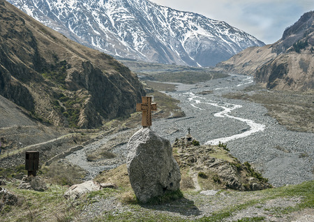 Georgia . Military - Georgian road through the village of Upper Lars . The graves of those killed in...
