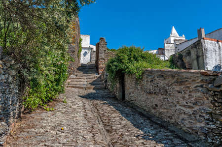 Portugal, Monsaraz. All buildings and streets pavement made ââof rough stone. All buildings are covered with plaster and painted white. Sunny spring day, a bright blue sky.のeditorial素材
