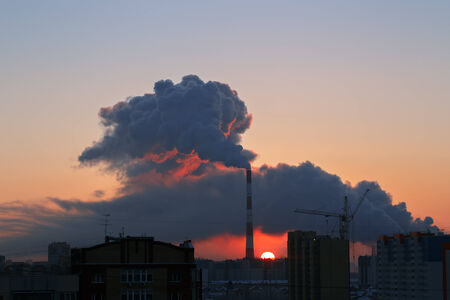 Beautiful cityscape at sunrise with smoking pipe