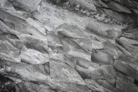A fragment of a stone wall or rock cliff close-up. Natural abstract background from stone rock.の写真素材