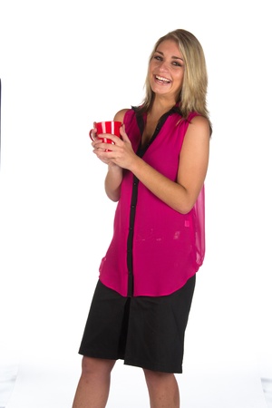 Young woman looking at camera with coffee cup she is holding isolated on whiteの写真素材