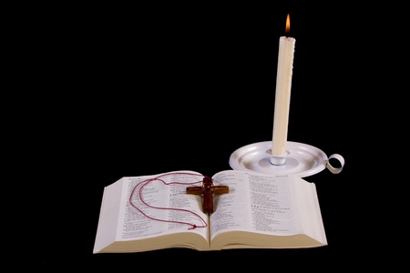 Open bible with burning candle - isolated on black - Norrow field of view - Focus on textの写真素材