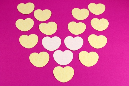 Yellow and light pink symbols of love on a dark and bright pink background.の写真素材