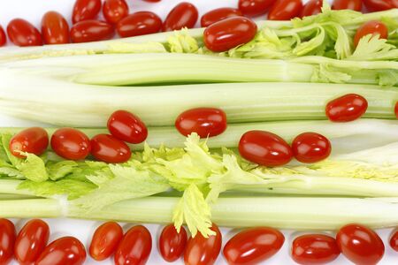 Fresh long green vegetable and small round red fruit mix on white.の写真素材