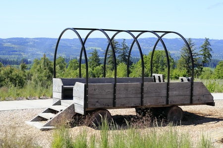 Empty benches in a step up to open stagecoach wagon made of wood and metal with logs for wheels.の写真素材
