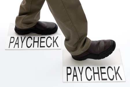 Person stepping from one paycheck to another paycheck.の写真素材