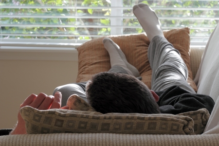 Adult caucasian male laying with his head on a pillow on a couchの写真素材