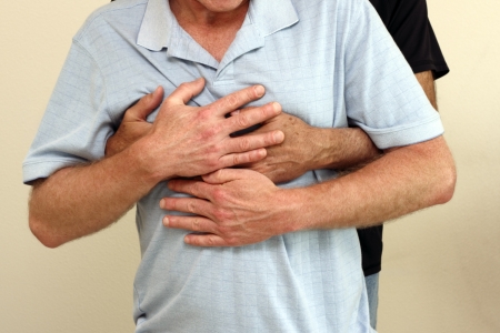 Man behind another man holding the man in front with his arms and hands wrapped around his chest  The man in front has his hands on top of the man who is holding him の写真素材