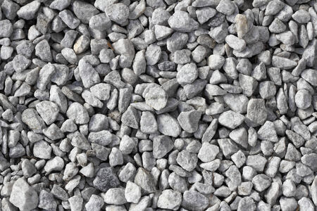 Gray white stones that act as gravel for drainage in flowerbeds and plantings in a wide variety of...