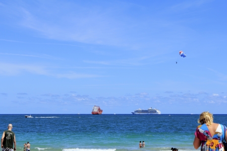 FORT LAUDERDALE, FLORIDA - APRIL 8, 2013  Colorful variety of various boats, people and parasailer off the shore of Fort Lauderdale, Florida beach on a warm bright blue sky spring day in the tropics のeditorial素材