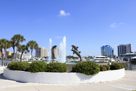 SARASOTA, FLORIDA - MAY 9, 2013: Dolphin Fountain sculpted by Steven C. Dickey, donated by Marina Jacks at the end of Sarasota Island Park and Marina with downtown buildings in the background.のeditorial素材