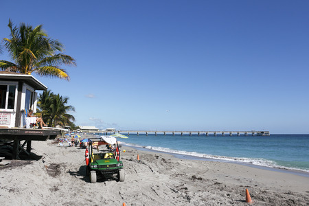 Dania Beach, FL, USA - December 7, 2014: A lifeguard tower overlooking this Atlantic coast beach on a sunny day.  A lifeguard and parked emergency vehicle on the coast.のeditorial素材