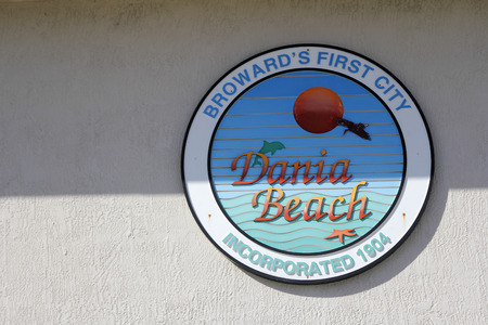 Dania Beach, FL, USA - December 7, 2014: A colorful round sign on a building that says, Broward s First City Dania Beach, Incorporated 1904. A Dania Beach sign.のeditorial素材