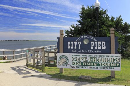 Southport, NC, USA - September 30, 2015: Southport City Pier and signs entrance to the wooden pier outside on a sunny day. City Pier of Southport signs on an autumn day.のeditorial素材
