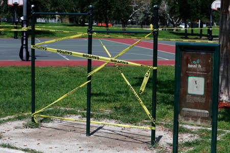 Pompano Beach, FL, USA - April 7, 2020: Yellow and black caution tape blocking access to chin-up...