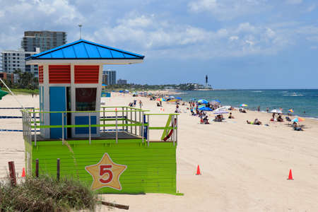 Pompano Beach, FL, USA - July 2, 2021: Pompano Beach Atlantic Ocean coast looking north toward the Hillsboro Inlet Lighthouse. Plenty of people enjoying Pompano Beach shore and water north of the pierのeditorial素材