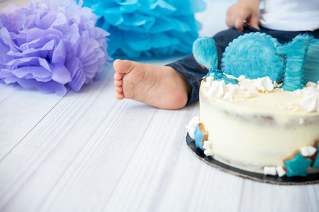 Festive background decoration for birthday with cake, letters saying one and blue balloons in studio, Boy Birthday .Cake Smash first year concept. birthday greetings.の写真素材