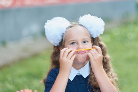 Portrait of beautiful young first-grader Farewell Bell. day of knowledge. beginning of the school year.の写真素材