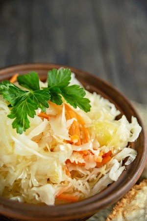 Sauerkraut is fermented cabbage and carrot. fermented food in countries such as Russia. Poland or German, Ukraine. salad homemade sauerkraut in fictile ar on tableの写真素材