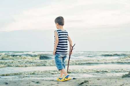 Boy drawing on sand at seaside. Child drawing sand by imaginary on beach for learning. Happy childhood. summer vacation at sea or oceanの写真素材