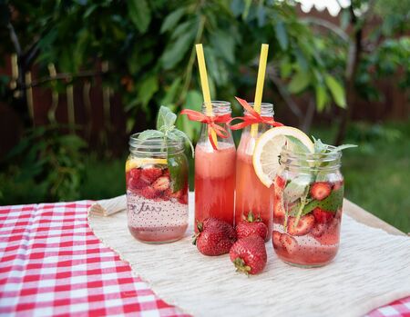 Strawberry and mint infused detox water. strawberry lemonade with ice and mint as summer refreshing drink in jars. Cold soft drinks with fruitの写真素材