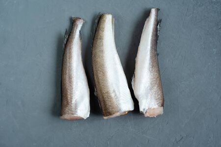 Raw fish hake. Five Raw fish fillet on grey background, food background. top view.