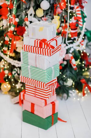 Pile of wrapped presents under Christmas tree. concept of Christmas and New Year. group of gift boxes under x-mas tree on wooden floor. Background. Selective focus.の写真素材