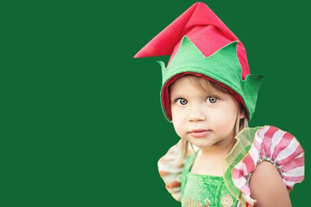 Child waiting for Christmas in wood in juli. portrait of little girl near christmas tree. Baby decorating pine. winter holidays and people concept. Merry Christmas and Happy Holidays. Color bokehの写真素材