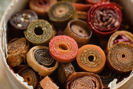 Sweet pureed fruit pastille. Fruit roll-ups homemade. Natural sweets from dried berries and fruits. mix of raspberries, currants, apples, bananas, strawberries, plums, pumpkins. healthy snack conceptの写真素材