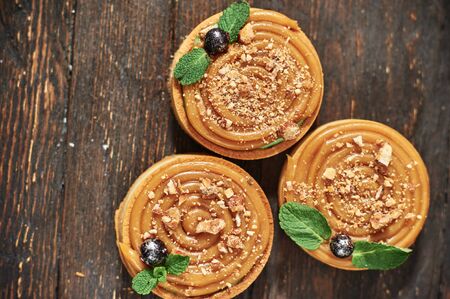 tart with salted caramel french dessert. Food industry, mass or volume production. dessert on wooden...