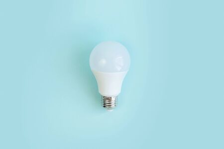 one LED light E27 bulb on blue background. energy saving Eco power concept. minimalism. Flat lay....