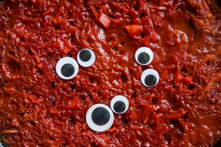 chopped tomatoes and beets for borsch. funny vegetable with toy googly eyes. Selective focus. Macro....