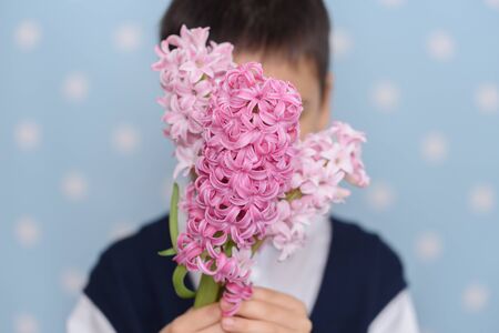 Cute little child boy with bouquet of pink flowers for gift. present for mother father day. concept...