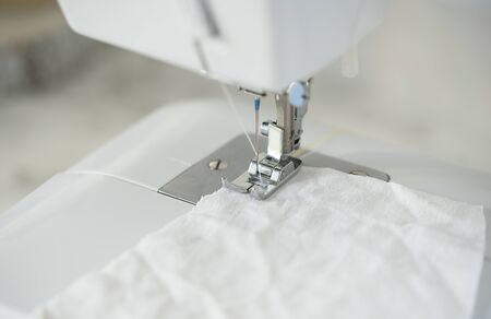 Macro view of Detail on sewing machine. Selective Focus. Homemade medical mask in process. DIY of...