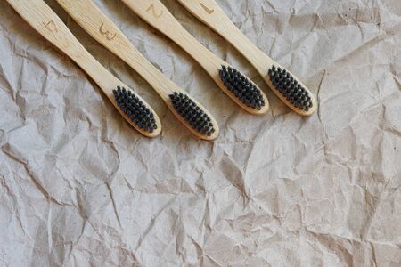 Set of bamboo toothbrushes with black brush bristles. Dental care with eco friendly bamboo tooth brush on paper background top view. Ecology concept. Dental zero waste protection Save the world.の写真素材