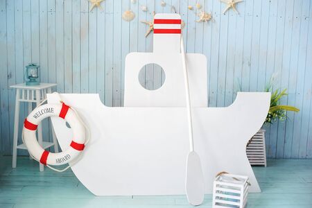 Festive background decoration for birthday. Cake Smash first year concept. Big wooden ship background. Decor in style of sea travel. Sea thematic photo session decoration of daylight studio.の写真素材