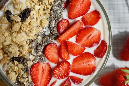 Healthy breakfast superfood smoothie bowl topped with granola and strawberry. close up. delicious berry smoothie bowl. vegan raw food. Selective focus. Flatlayの写真素材