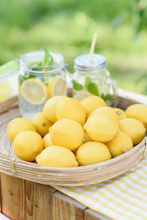 Plate with ripe fresh lemons and lemonade sassy water. Vitamins concept. copy space. Strengthening immunity concept. Tropical fruit. Organic citrus fruits for a healthy diet.の写真素材